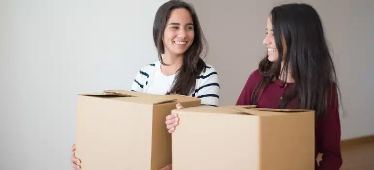 Two women holding boxes