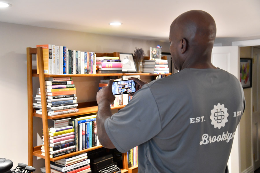 U.Santini worker taking pictures of books on bookshelf