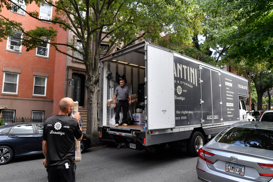 Movers loading furniture onto moving truck