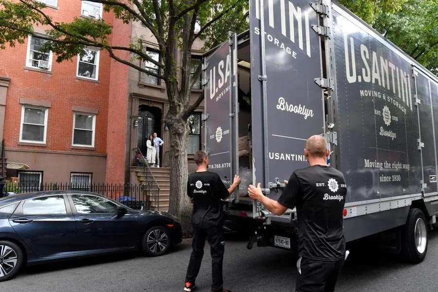 Movers close the doors to their truck before moving a piano in New York City
