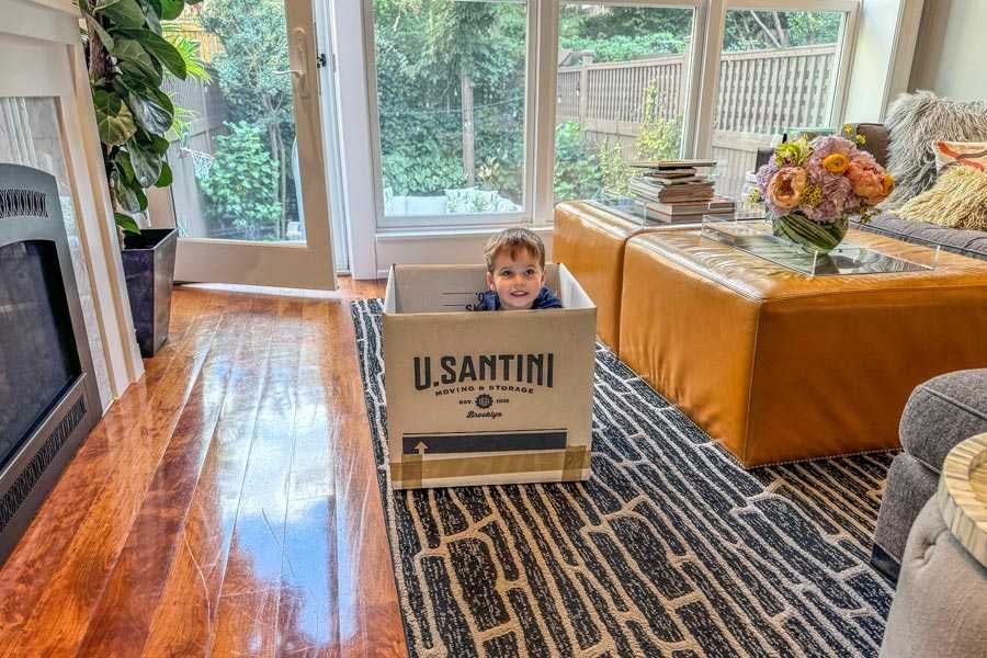 A kid playing with a U.Santini box used for relocating across New York City
