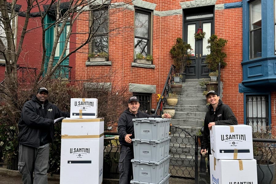 U.Santini movers with boxes standing in front of New York Brownstone